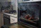 Zagorjela hrana u pećnici s vidljivo crnim naslaga i dim