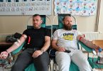 Dva muškarca sjedeće na zelenim stolicama tijekom dobrovoljne akcije davanja krvi