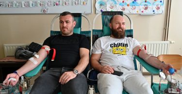 Dva muškarca sjedeće na zelenim stolicama tijekom dobrovoljne akcije davanja krvi