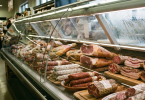 Različiti suhomesnati proizvodi izloženi u hladnjači mesnice ili supermarketa