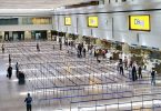 Prazna zona čekanja u terminalnoj zgradi međunarodnog aerodroma s redovima barijera.