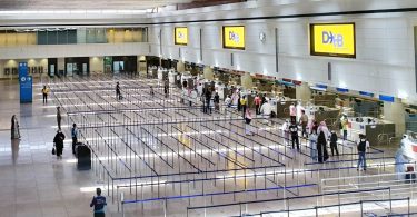 Prazna zona čekanja u terminalnoj zgradi međunarodnog aerodroma s redovima barijera.