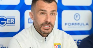 Trener pred mikrofonom tijekom sportske konferencije za medije