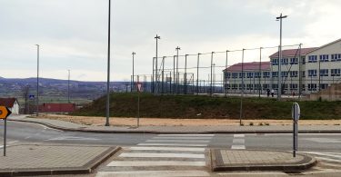 Sportski teren i parkiralište ispred osnovne škole sa modernom oplatom i svjetlosnom infrastrukturom
