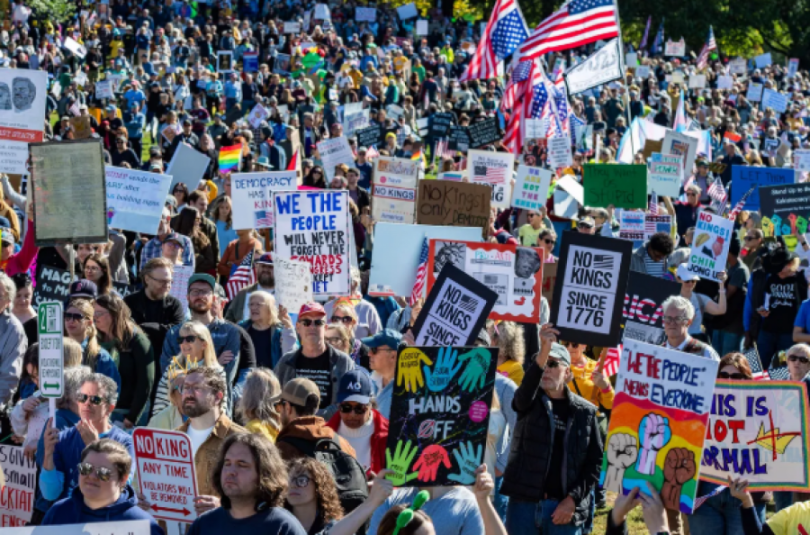 Velika masa demonstranata na ulici s plakatima i američkim zastavama tijekom prosvjeda