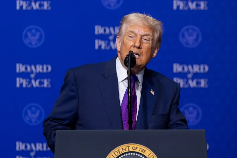 Američki predsjedenik Trump govori pri postolju sa znakom Odbora za mir