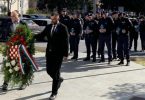 Policijski službenici polažu cvijeće kod spomen-obilježja tijekom službene ceremonije