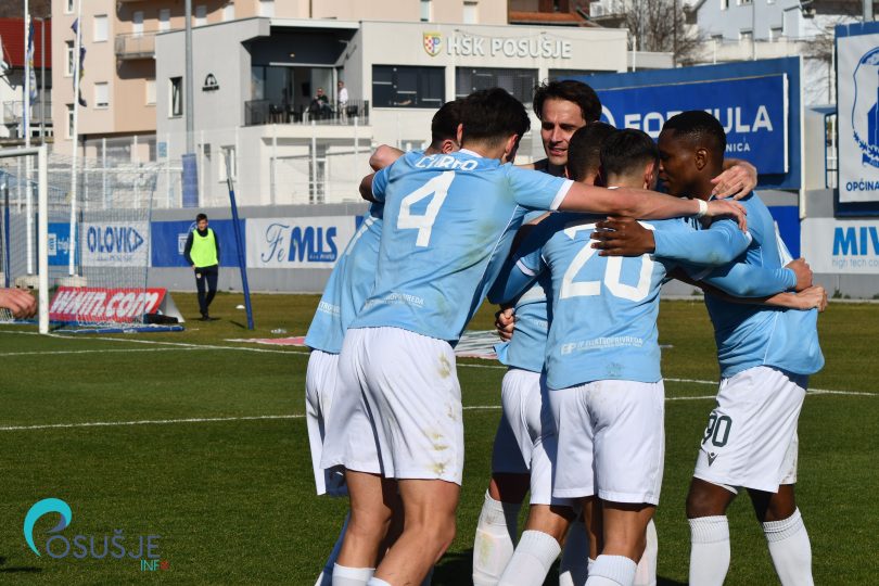 Nogometaši u plavim dresovima okupljeni u grupi slave postignut gol tokom utakmice