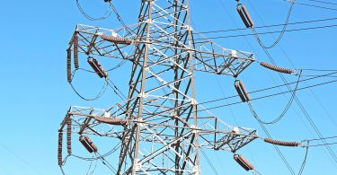 Visokonaponski elektroenergetski stubovi i vodovi protiv plavog neba