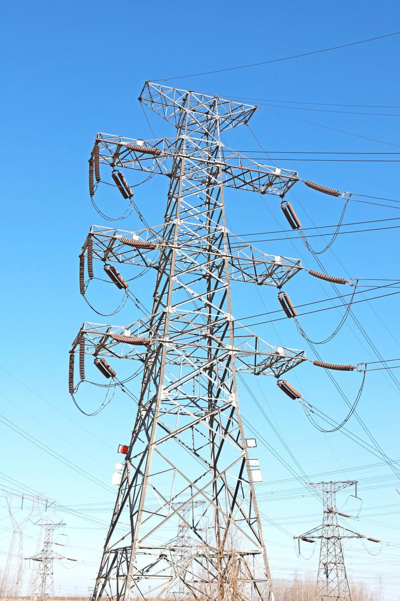 Visokonaponski elektroenergetski stubovi i vodovi protiv plavog neba