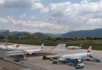 Putnički avioni na aerodromu Sarajevo s pistom i planinama u pozadini