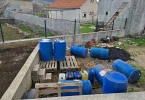Plave kanistre s gorivom i kutije cigareta složene na paletama tijekom policijske akcije