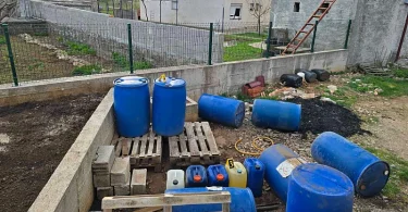 Plave kanistre s gorivom i kutije cigareta složene na paletama tijekom policijske akcije