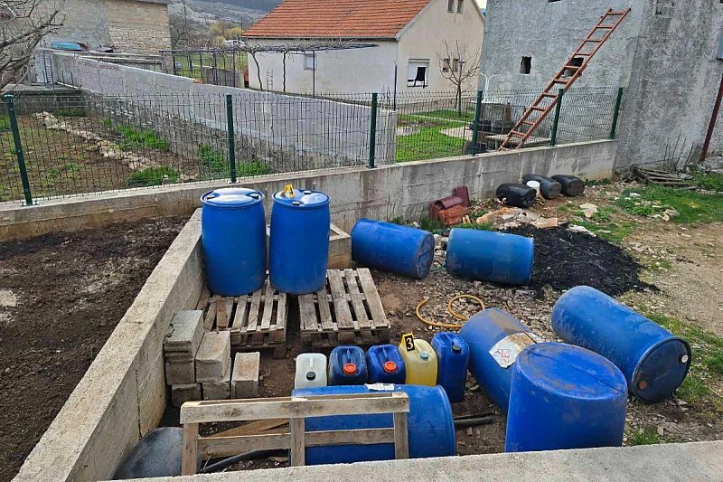Plave kanistre s gorivom i kutije cigareta složene na paletama tijekom policijske akcije