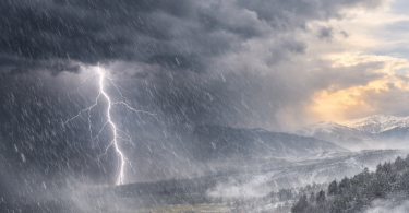 Dramatična scena nevremena s gromom iznad planinama i snježnog krajolika