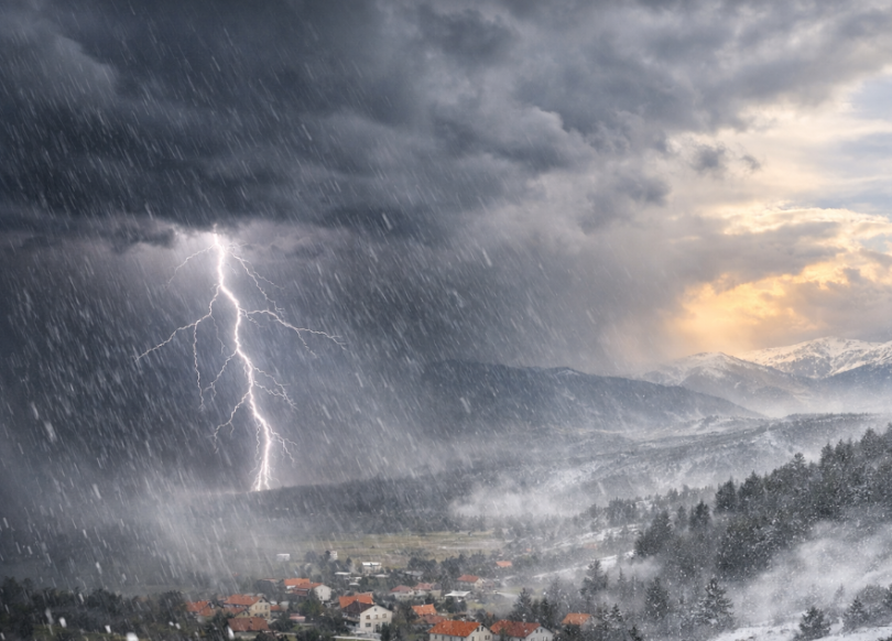 Dramatična scena nevremena s gromom iznad planinama i snježnog krajolika