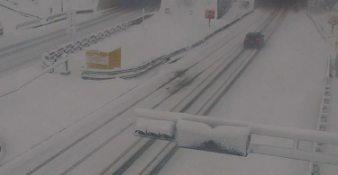Autocesta pokrivena snijegom s vozilima u magli tijekom nevremena