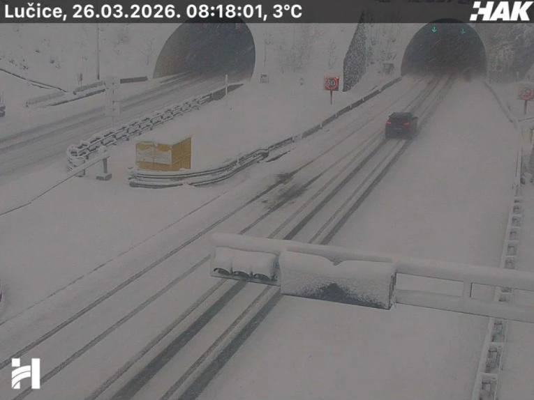 Autocesta pokrivena snijegom s vozilima u magli tijekom nevremena