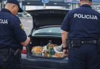 Policajci otvaraju prtljažnik automobila tijekom granične kontrole i provjere dozvoljenih namirnica