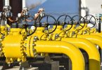 Žuti industrijski cjevovodi s ventilima i regulatorima za transport plina