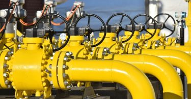 Žuti industrijski cjevovodi s ventilima i regulatorima za transport plina