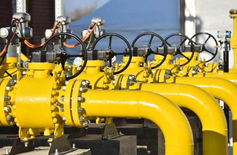Žuti industrijski cjevovodi s ventilima i regulatorima za transport plina