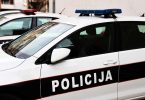Bijelo-plava policijska vozila s uključenim rotacijskim svjetlima na cesti