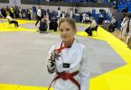 Judašica u bijelom kimonoju s crvenim pojasom i bronznom medaljom