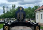 Crni spomen-obilježje s grbom, šahovnicom i pločama posvećeno pripadnicima HVO-a