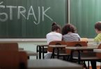 Učenici sjede u učionici s natpisom štrajk na pločи tijekom štrajka upozorenja