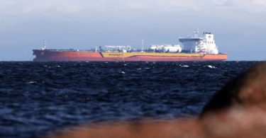 Veliki naftni tanker na otvorenom moru s crvenim trupom i bijom nadgradnjom