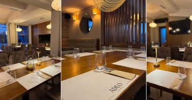 Elegantna blagovaonica restorana s drvenim detaljima, osvjetljenim stolicama i profesionalnim postavljanjem stolova