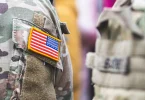 Američki vojnik u camoflage uniformi s američkom zastavom na ramenu