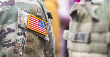 Američki vojnik u camoflage uniformi s američkom zastavom na ramenu