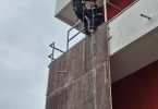Vatrogasac u uniformi spušta se užetom uz fasadu zgrade tijekom obuke