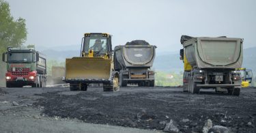 Građevinski strojevi i vozila tijekom radova na asfaltiranju ceste