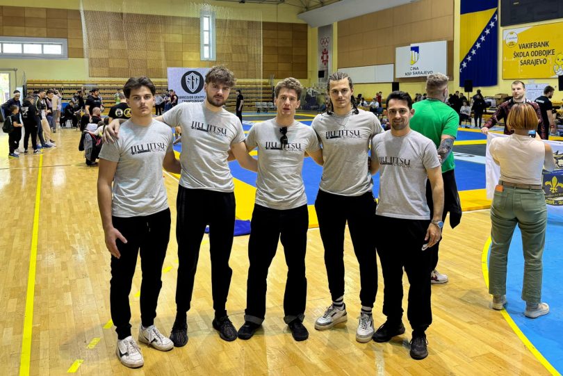 Grupa članova Poskoka u bijelim majicama pozira na sportskoj dvorani tijekom jiu-jitsu turnira