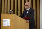 Muškarac u plavom odijelu govori za pulpitom s logom Vijeća Europe