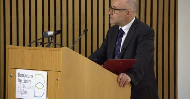 Muškarac u plavom odijelu govori za pulpitom s logom Vijeća Europe