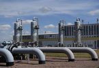 Veliki industrijski cjevovodi i postrojenja za plinsku distribuciju s rezervoarima u pozadini