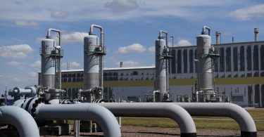 Veliki industrijski cjevovodi i postrojenja za plinsku distribuciju s rezervoarima u pozadini