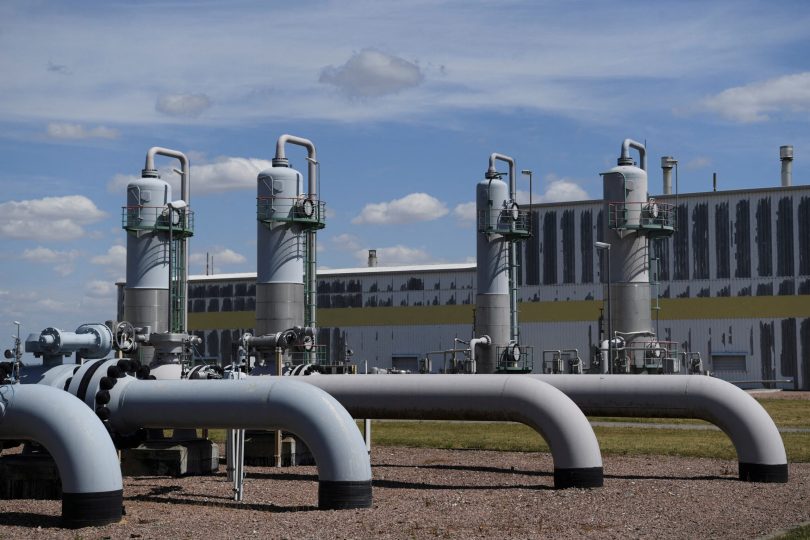 Veliki industrijski cjevovodi i postrojenja za plinsku distribuciju s rezervoarima u pozadini