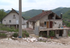 Oštećena kuća s urušenim zidovima i krovom u planinskoj okolici
