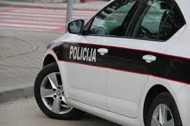 Bijelo-crno policijsko vozilo s natpisom Policija parkirano na cesti