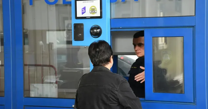 Putnik čeka na kontrolnoj točki na granici EU sa službenik koji provjerava dokumente