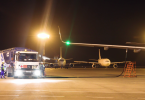 Kamion za prijevoz goriva s crijevoм povezan na avion tijekom noćnog punjenja na aerodromu