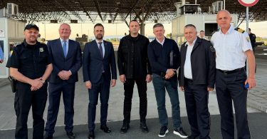 Grupa zvaničnika pozira za fotografiju na mjestu privremenog graničnog prijelaza