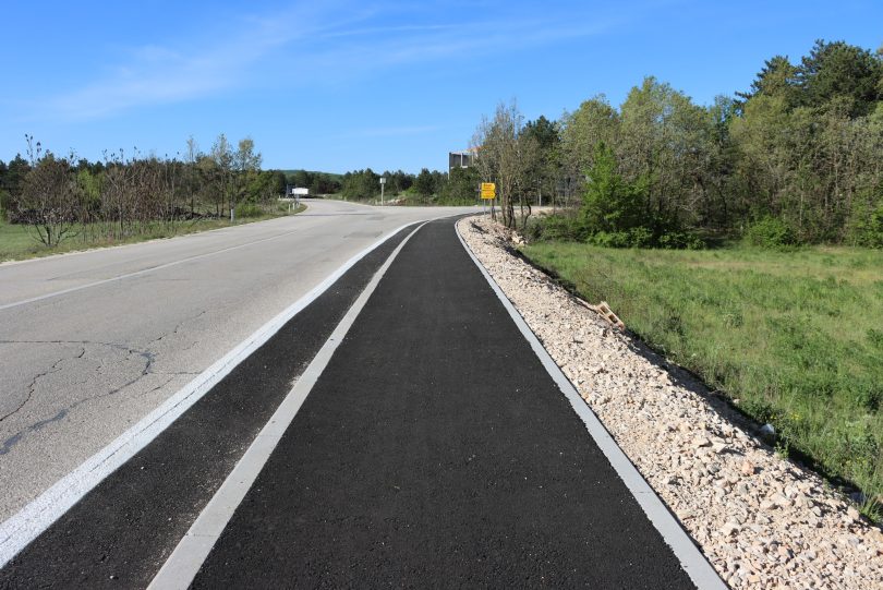 Novi asfaltni put sa betonskim rubnjacima i šljunčanom prugom uz cestu