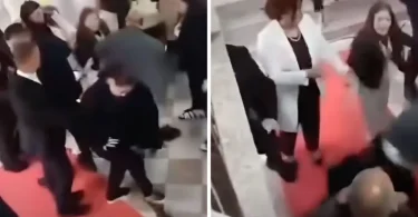 Grupa ljudi u sukobu na crvenom tepihu tijekom priredbe, uz prisutnost sigurnosti