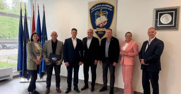 Grupa zvaničnika u službenim odijelima na sastanku suradnje MUP-a i Policijske akademije